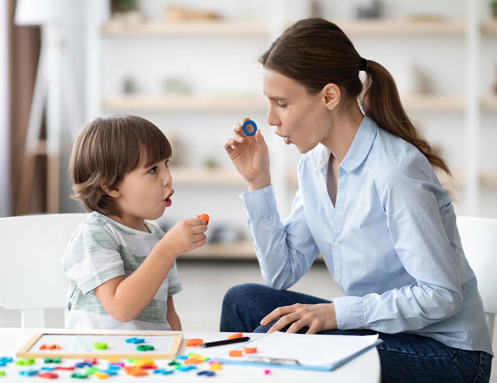 A teacher and child joyfully interacting with colorful objects in a playful, creative environment.