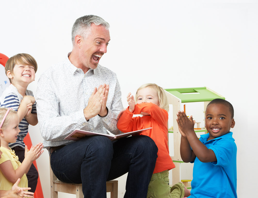 A joyful scene with a teacher o a group of children, all engaged and clapping, creating a lively and enthusiastic atmosphere.