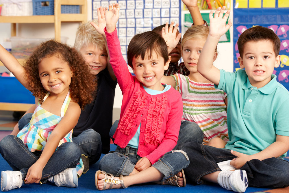 A cheerful group of children raising their hands, promoting a positive message about growth and a bright future.