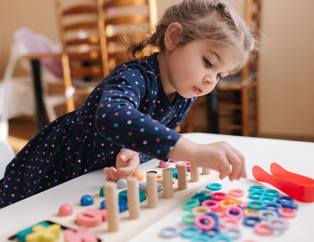 A young girl focused on engaging in imaginative play and learning