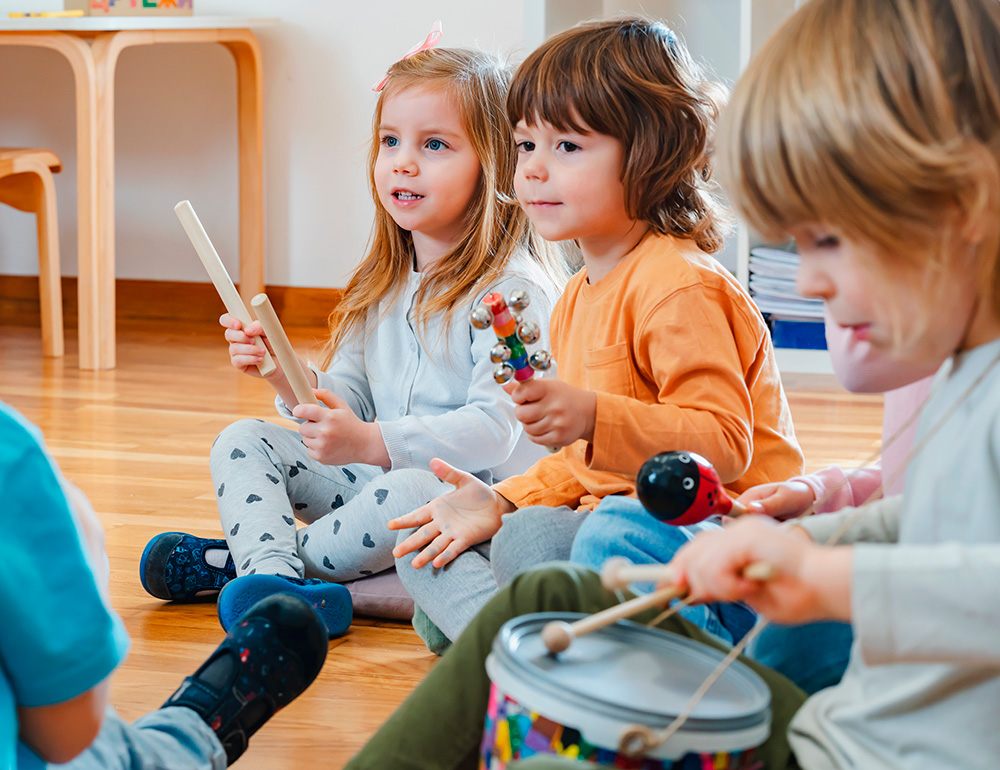 A group of children joyfully playing musical instruments, immersed in a fun and creative musical activity together.