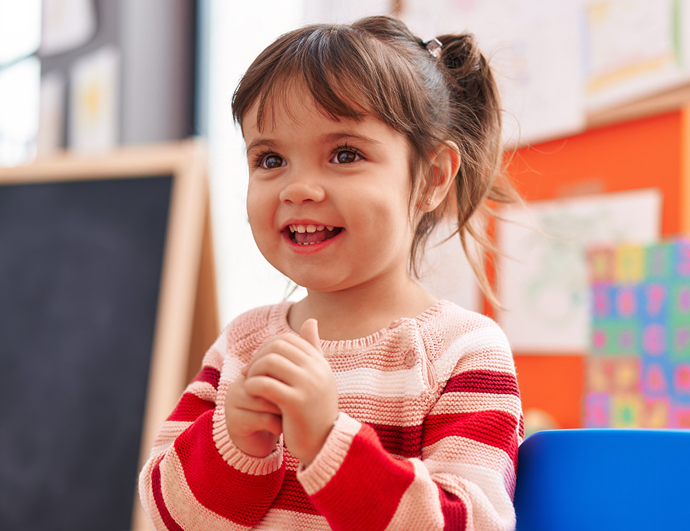 A smiling young girl, expressing joy and excitement, capturing a moment of happiness and engagement.