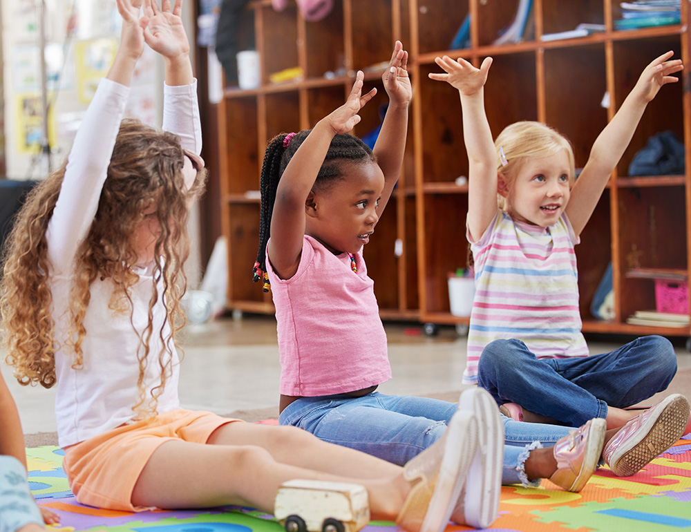 Group of Children, participating in an interactive activity, surrounded by a bright and welcoming classroom.