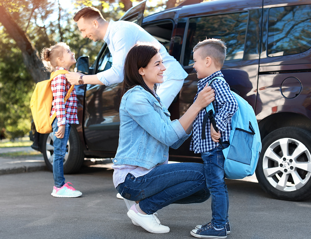 A family interacting by their children's smiling and preparing for an school, capturing a moment of joy and connection.